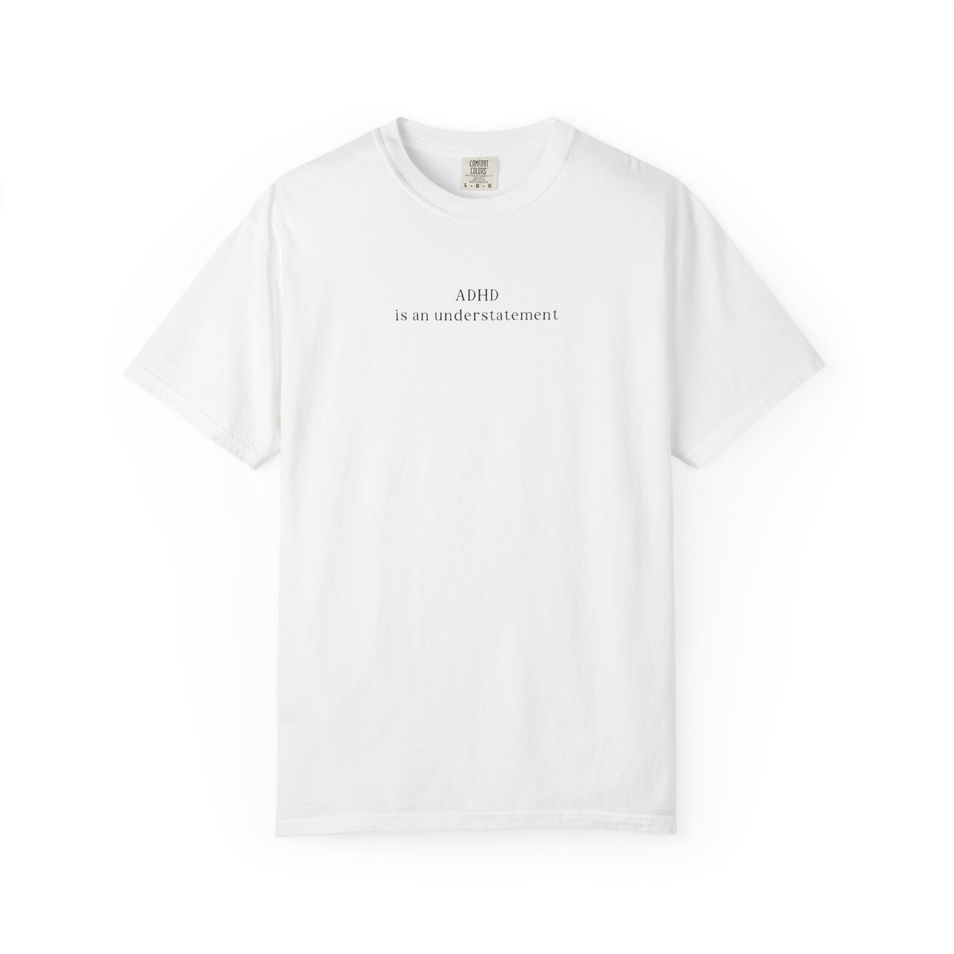 Minimalist white graphic t-shirt featuring the text 'ADHD is an understatement' printed in a small, elegant black font across the chest. Isolated flat lay product shot on a clean white background.