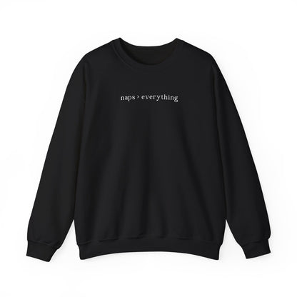 A black oversized sweatshirt featuring minimalist white text across the chest that reads 'naps > everything'. Clean studio product photography on a white background for the Barely Sane clothing collection.