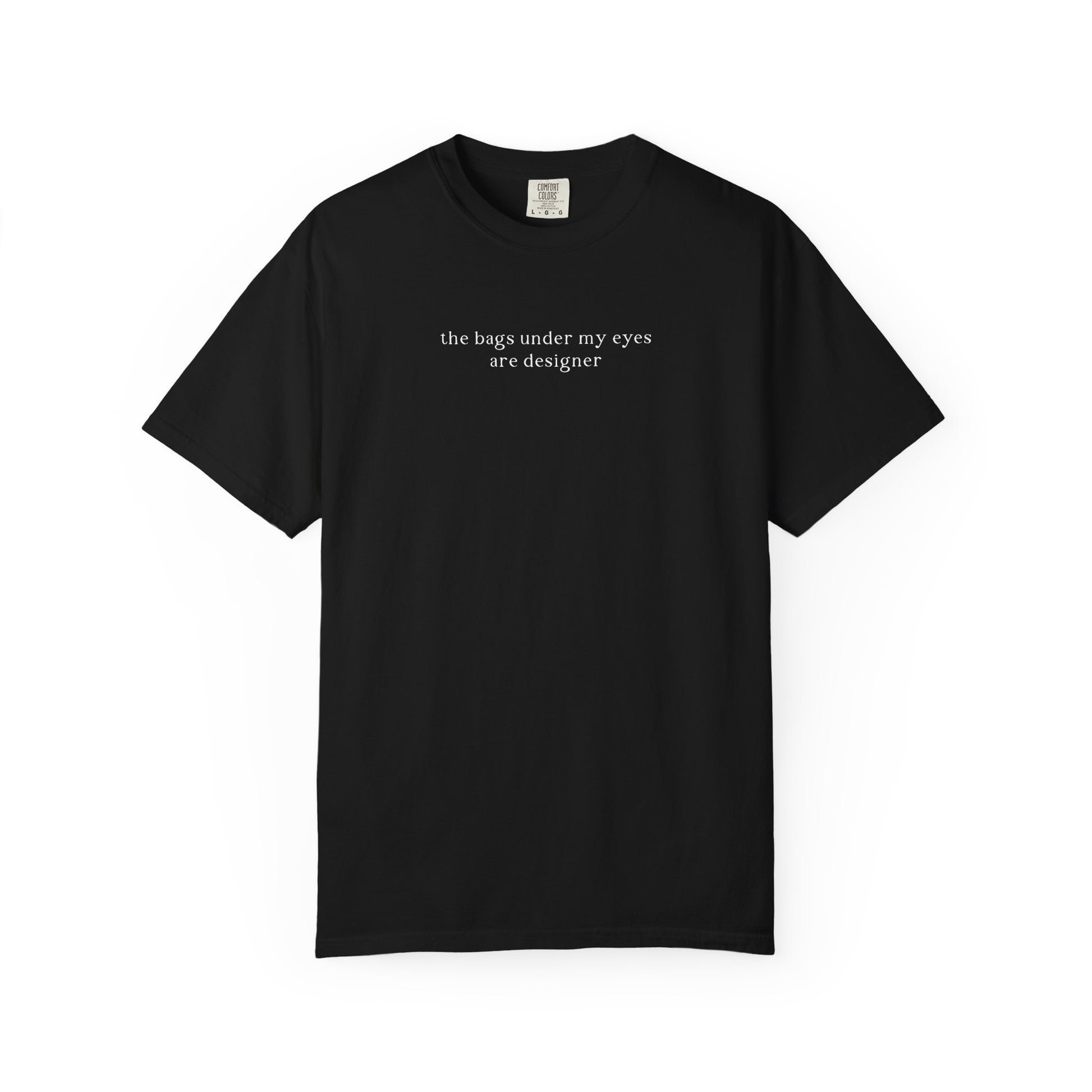 A black crewneck t-shirt with the white text 'the bags under my eyes are designer' printed across the chest. Minimalist studio product shot for the Barely Sane clothing collection.