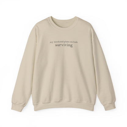 Beige sweatshirt with text 'my weekend plans include surviving' on a white background