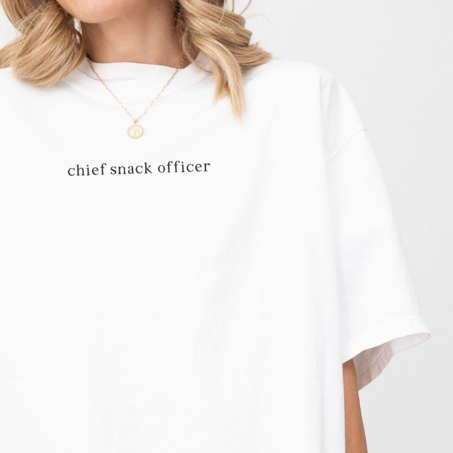 Person wearing a white shirt with 'chief snack officer' text