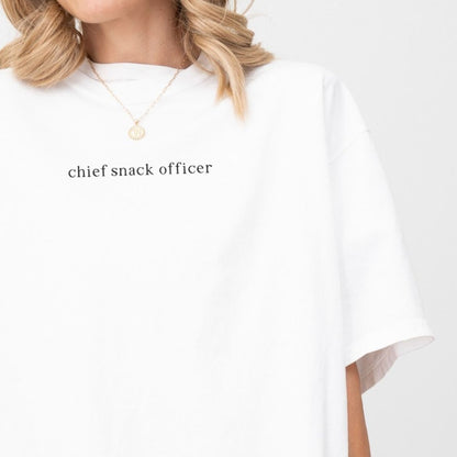 Person wearing a white shirt with 'chief snack officer' text